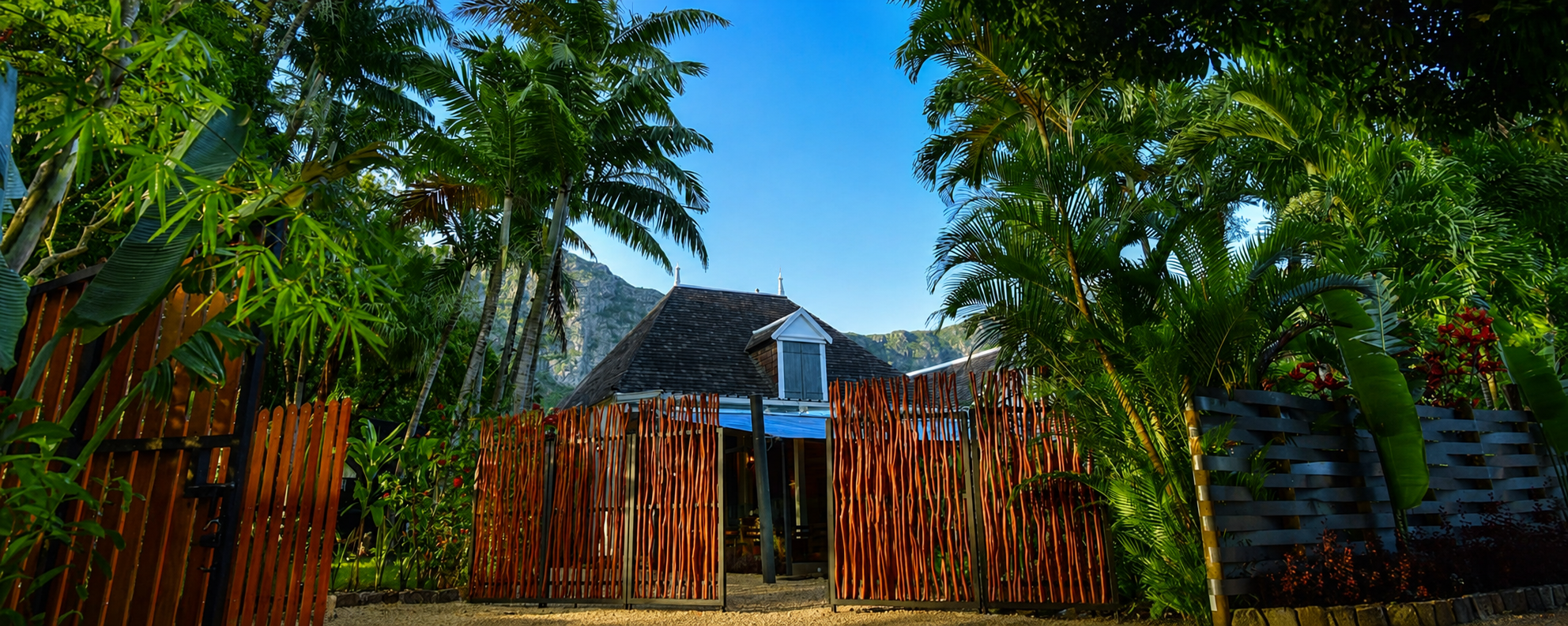 L'Assiette D'Antan tropical restaurant entrance surrounded by palm trees